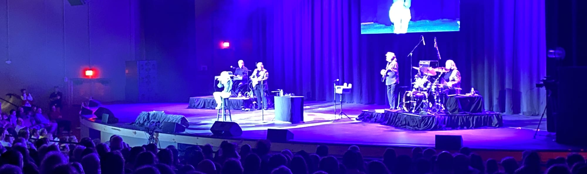 signer on stage in chair washed out by the lights Virginia Beach